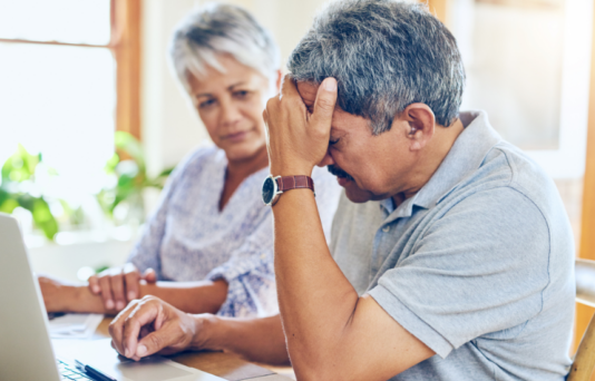 Shot of a mature couple looking stressed out while managing their paperwork together at home.