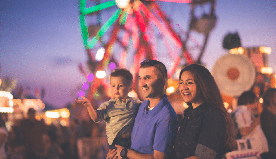 Parents with a young child at a country fair.