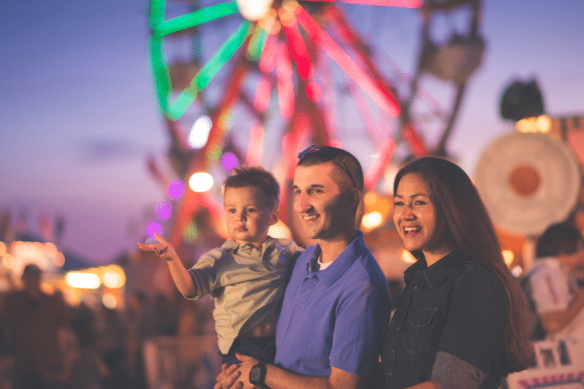 Parents with a young child at a country fair.