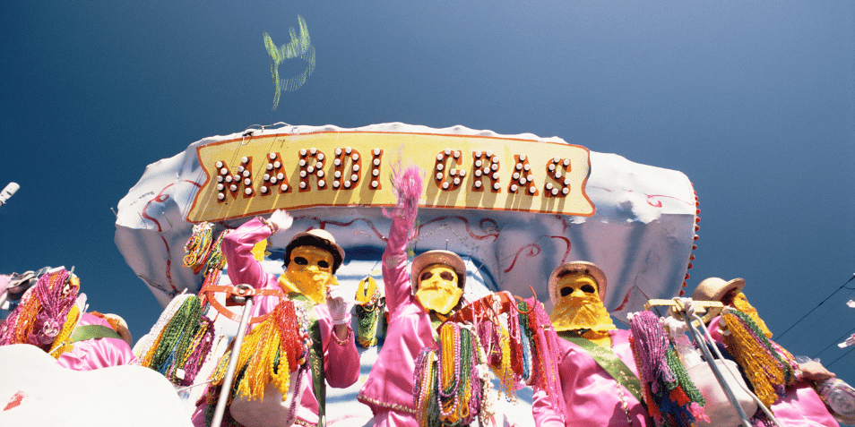 People throwing beads from float at Mardi Gras.