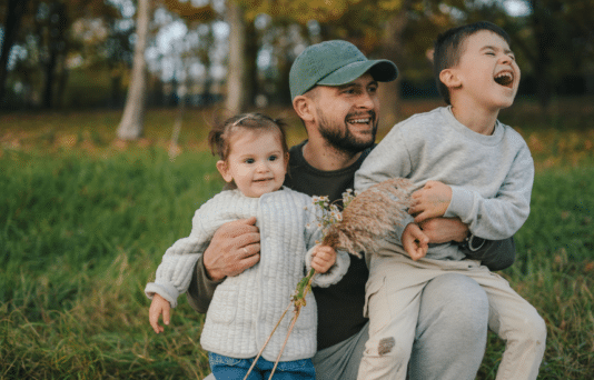 A dad with his two kids playing outside