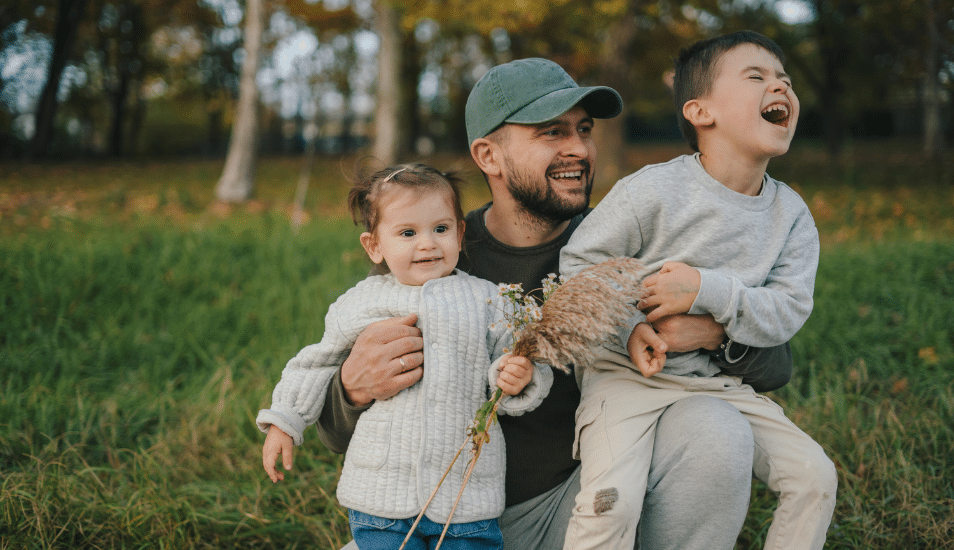 A dad with his two kids playing outside