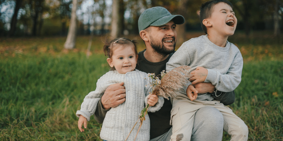 A dad with his two kids playing outside