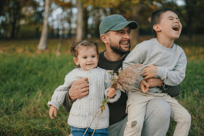 A dad with his two kids playing outside