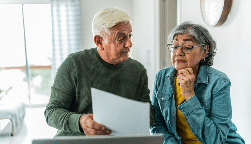 Senior couple using computer and doing home finances at home.