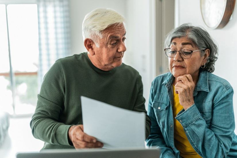 Senior couple using computer and doing home finances at home.