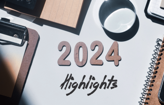 2024 highlights written in wooden letters and inscription on an office desk background.