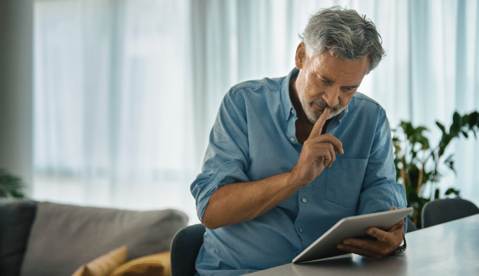 Middle-aged man in living room looking at his iPad.