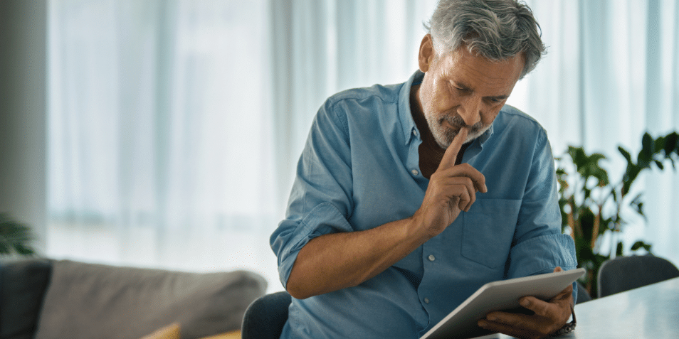 Middle-aged man in living room looking at his iPad.