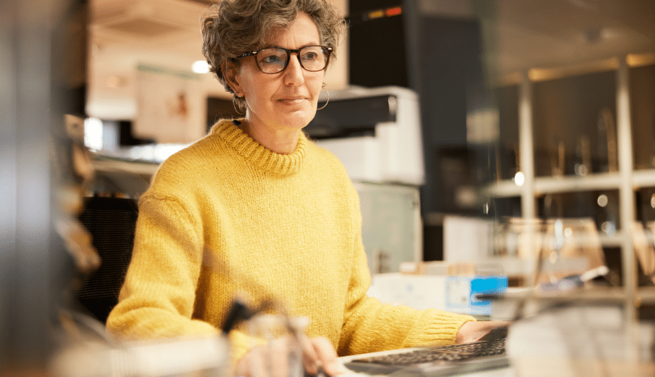 A middle-aged woman working with a computer.