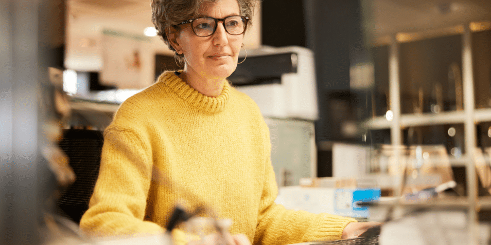 A middle-aged woman working with a computer.