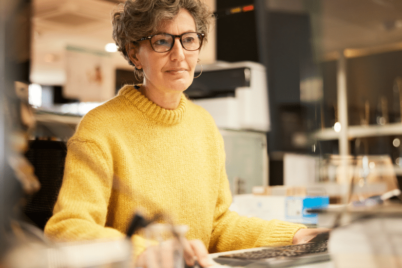 A middle-aged woman working with a computer.