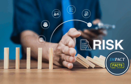 Businessman stops falling dominoes with hand, showing risk prevention.