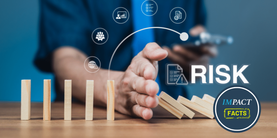 Businessman stops falling dominoes with hand, showing risk prevention.