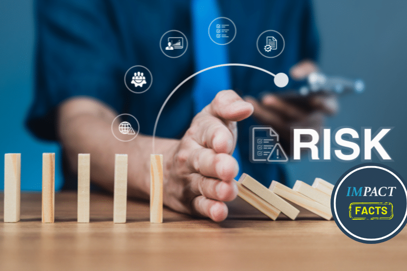 Businessman stops falling dominoes with hand, showing risk prevention.