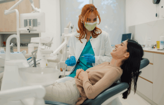Dentist talking with her patient in dental clinic.