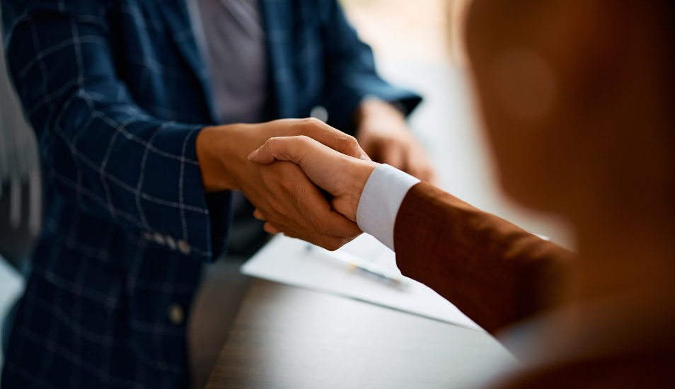 Close up of business people shaking hands in the office.