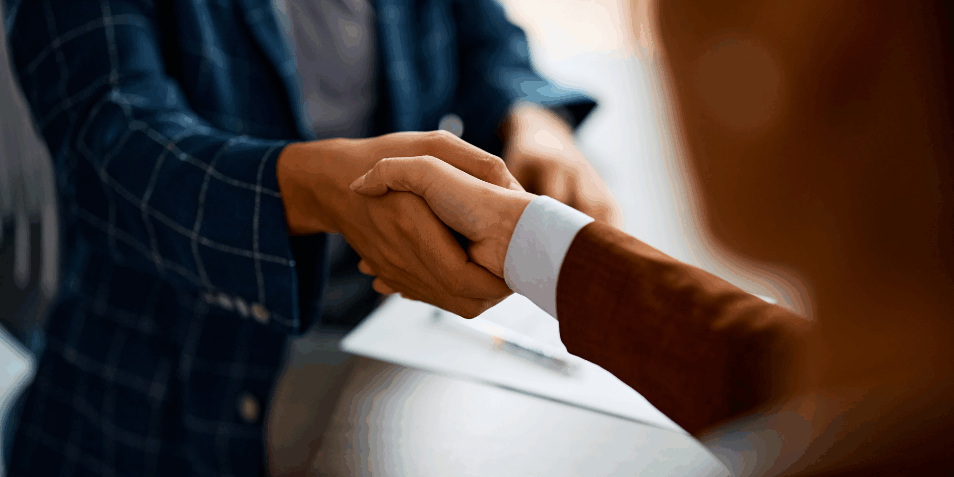Close up of business people shaking hands in the office.