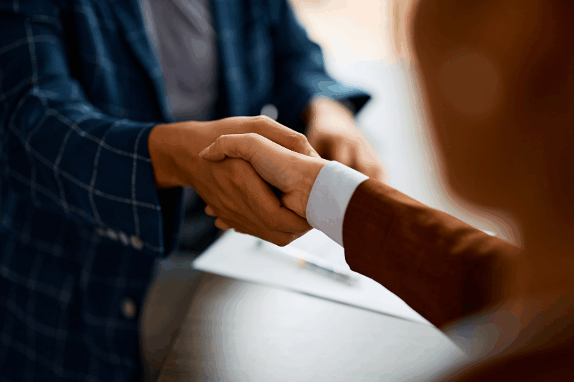 Close up of business people shaking hands in the office.