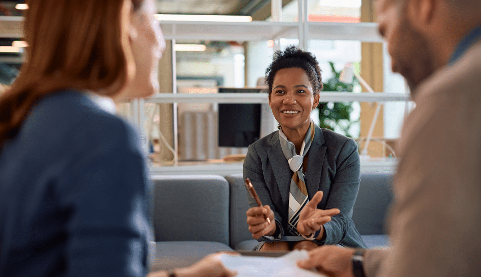 Happy black financial consultant having a meeting with her clients in the office.