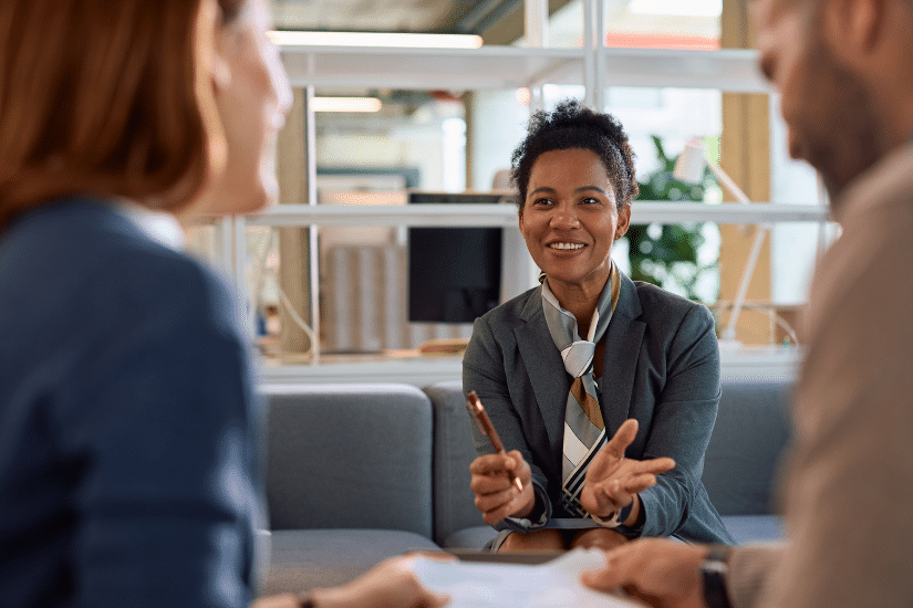 Happy black financial consultant having a meeting with her clients in the office.