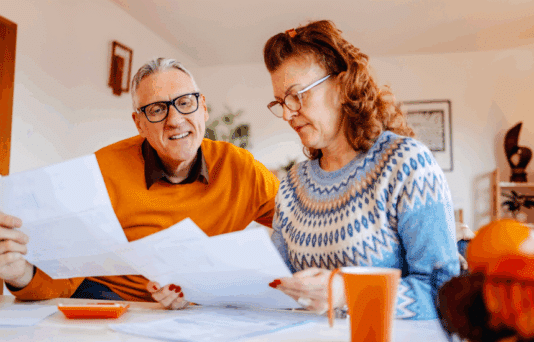 Mature adults spending time enjoying at home working on home finances together.