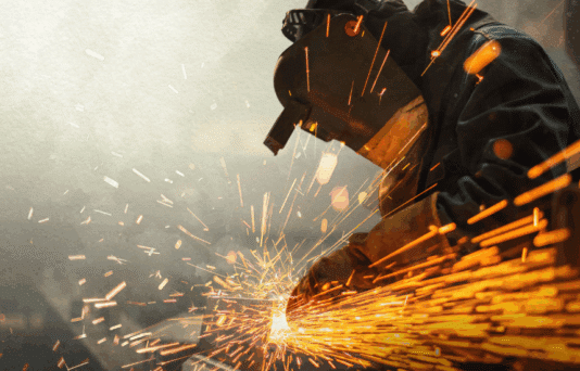 Metal worker using a grinder with sparks flying.