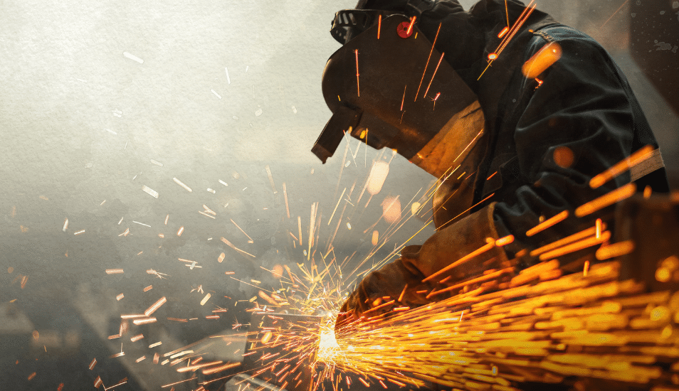 Metal worker using a grinder with sparks flying.