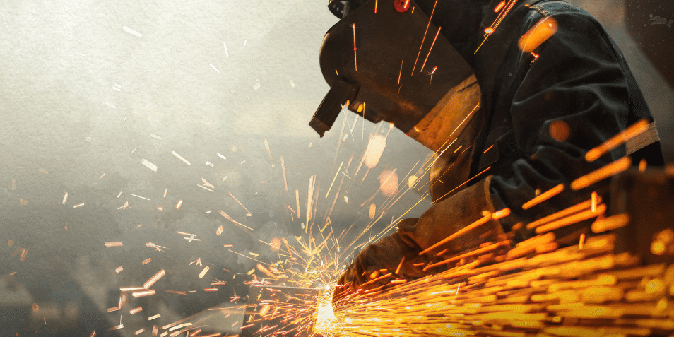 Metal worker using a grinder with sparks flying.