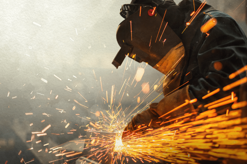 Metal worker using a grinder with sparks flying.