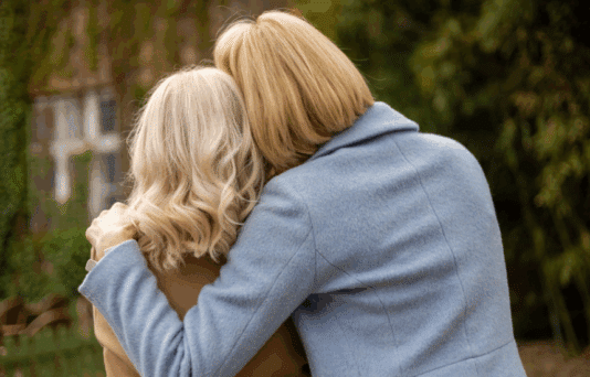 The back of two women embracing.