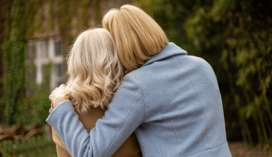 The back of two women embracing.