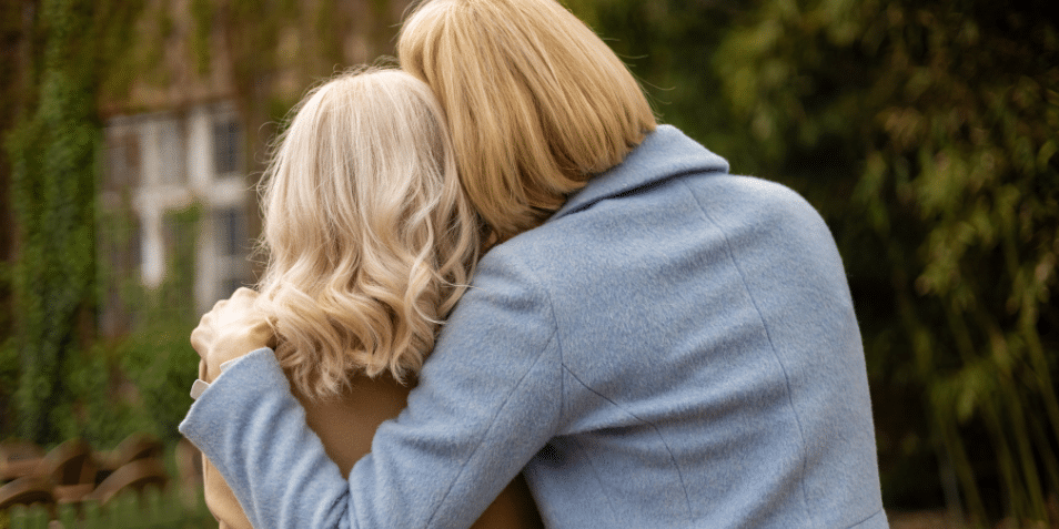 The back of two women embracing.