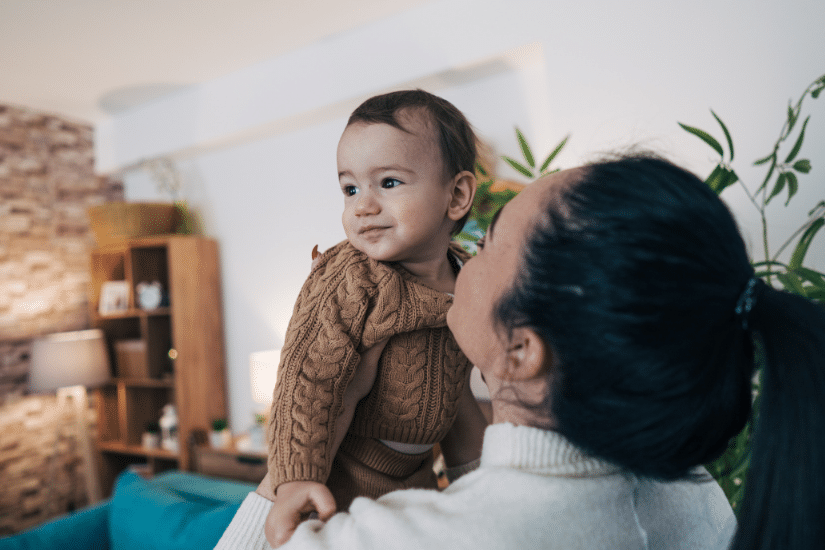 Mother holding her baby in the living room.