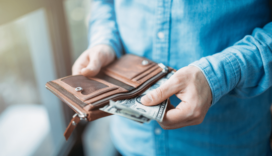 A person pulling out cash from their wallet.