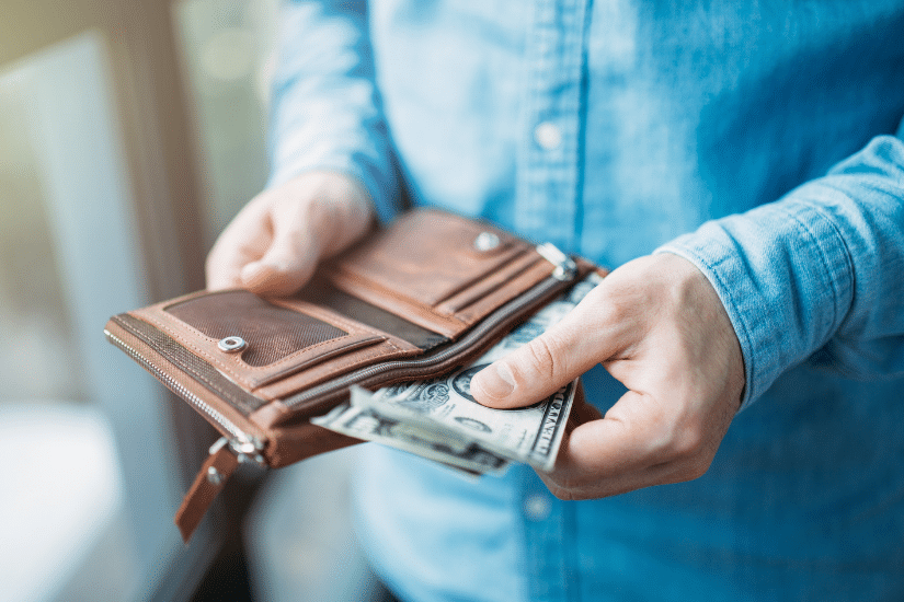 A person pulling out cash from their wallet.